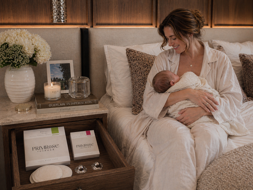 New mother breastfeeding baby with natural postpartum breast care essentials