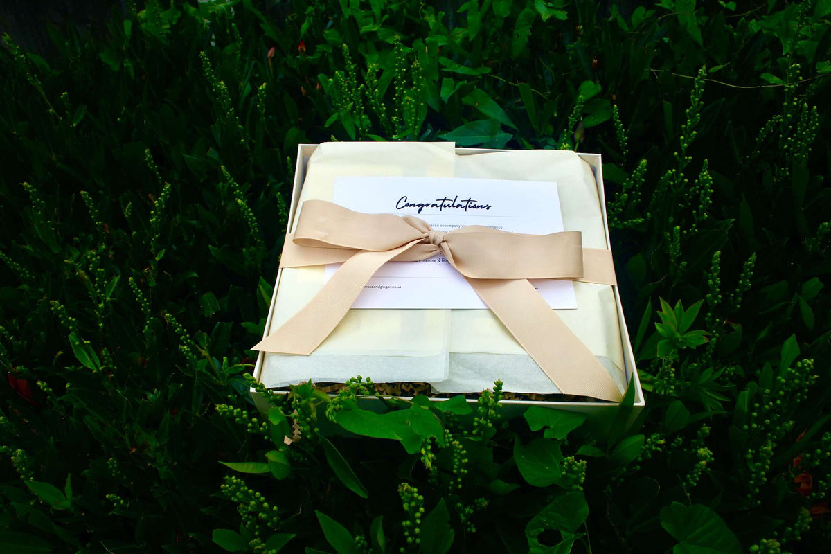 Luxury postpartum wellness gift box wrapped with ribbon for new mothers