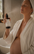 Woman using calming chamomile mist as part of postpartum wellness ritual